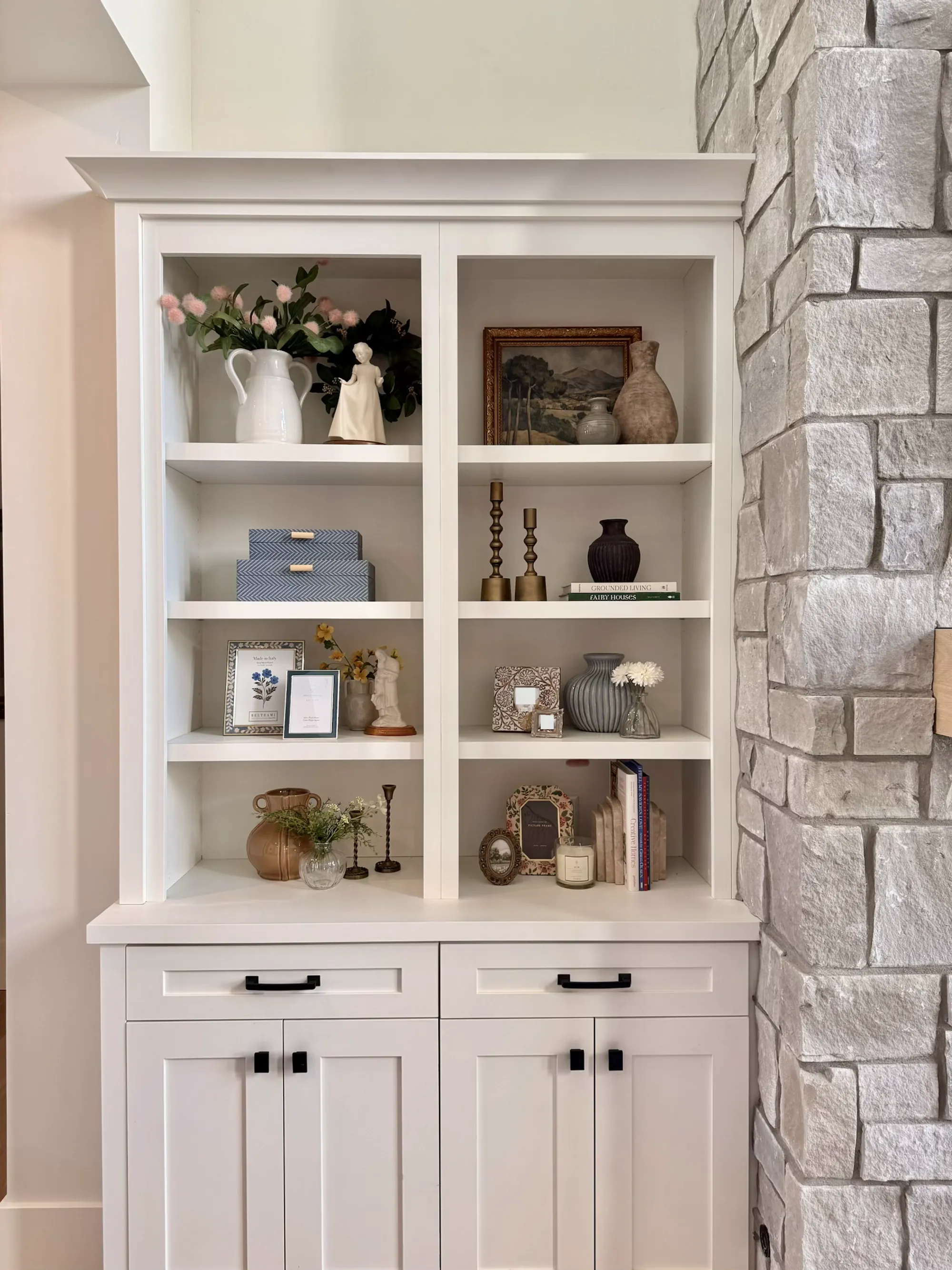 Custom white built-in shelving styled with art and ceramics by BK Toolbox